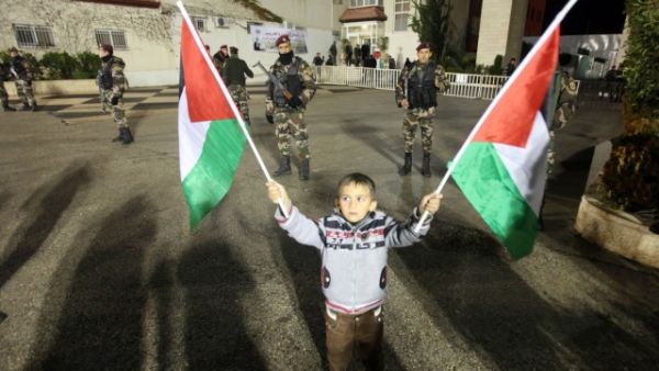 A young Palestinian boy holds his national flag. (AFP photo/Abbas M)