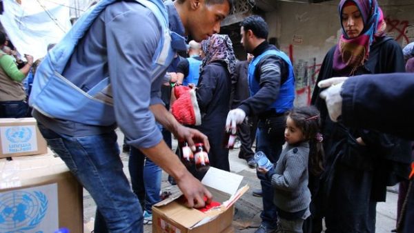 Palestinians gather at an UNRWA aid distribution. (AFP/File)