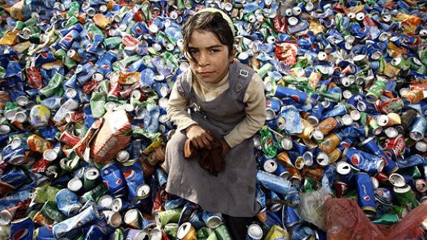 An Iraqi girl from an impoverished family searches through garbage for recyclable items at a waste dump on the outskirts of the shrine city of Najaf. (AFP/file)