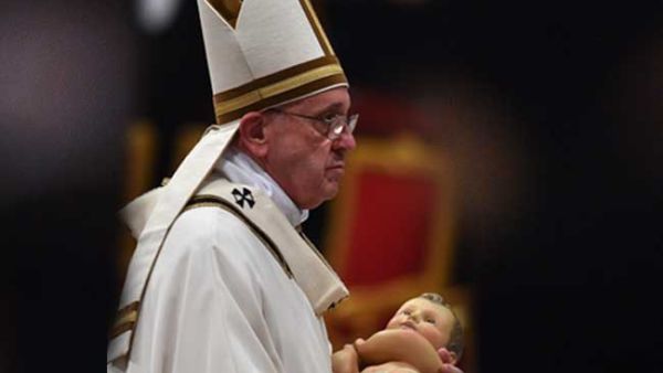 Pope Francis carries the statue of baby Jesus during a mass on Christmas eve marking the birth of Jesus Christ on December 24, 2015 at St Peter's basilica in Vatican. (AFP)