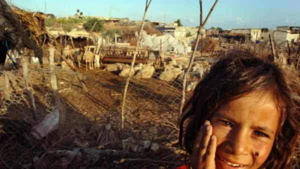 A young Palestinian girl stands in front of her Bedouin tent slum, in the seaside al-Mawasi area.