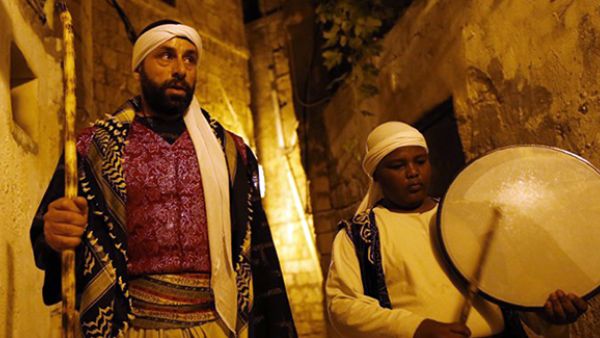 An Arab-Israeli Christian man carrying out the role of a "Musaharati", the traditional figure who awakens Muslims for the "Suhur",  walks in the street rousing Muslim residents in the northern Israeli port city of Acre. (AFP/File)