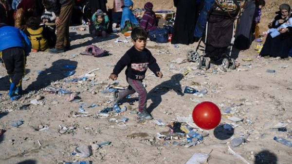 A displaced Iraqi boy, who fled the violence in the Islamic State (IS) group stronghold of Mosul, plays with a ball as he waits for transportation to IDP camps near the town of Bartella (Dimitar DILKOFF / AFP)