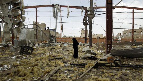 A Yemeni woman inspects the rubble of a factory allegedly targeted by Saudi-led airstrikes in the Yemeni capital Sanaa. (AFP/Mohammed Huwais)