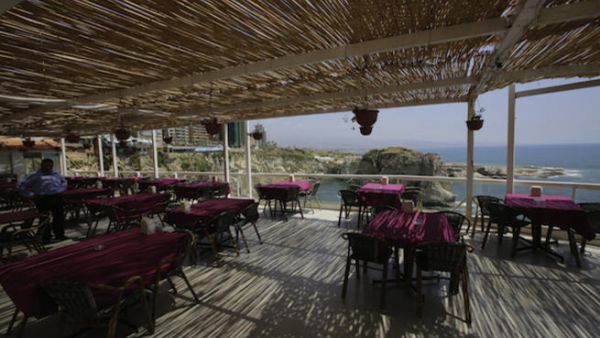 Empty tables are seen in a restaurant on the Beirut's corniche, with a sea view of the capital's landmark Pigeon's Rock, which was once crowded by tourists mainly from the Gulf states at this time of the year (Source: AFP/JOSEPH EID)
