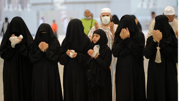 Muslim pilgrims recite prayers after throwing pebbles at pillars in the "Jamarat" ritual which symbolizes the stoning of Satan on the third day of the Eid Al-Adha holiday in Min. (Image credit: AFP)