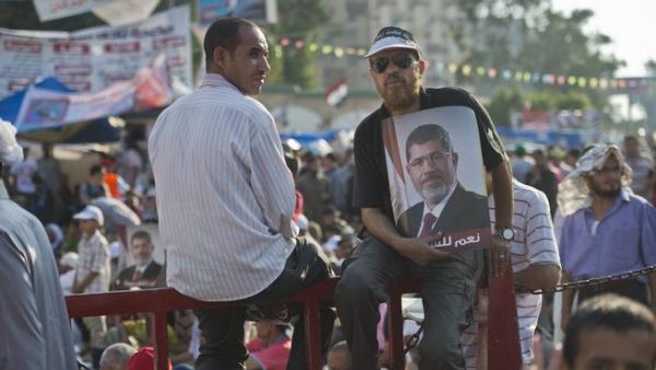 A man holds a portrait of deposed president Mohamed Morsi during a rally in his support outside Rabaa al-Adawiya mosque in Cairo (AFP/KHALED DESOUKI)