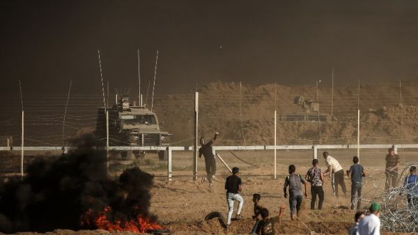 Palestinian protesters throw stones towards Israeli forces during a demonstration along the border between Israel and the Gaza strip, east of Gaza city on July 27, 2018. (MAHMUD HAMS / AFP)