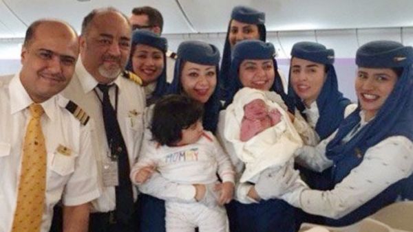The Saudi Arabian Airlines crew are pictured holding the newborn baby girl who was born on a flight from Jeddah to New York. (Twitter)