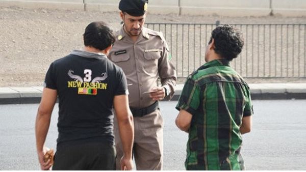 A policeman checks the permits of residents in Saudi Arabia. (Arab News)