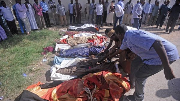 Relatives gather to look at the dead bodies of ten people including children after a raid on their farms in Bariire, some 50 km west of Mogadishu, on August 25, 2017 (AFP)