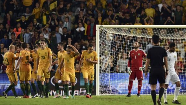 Australian players (L) celebrate their third goal as Jordan goalkeeper Amer Shafi (C) looks on during the World Cup Asian qualifier football match between Australia and Jordan in Sydney on March 29, 2016.
SAEED KHAN / AFP