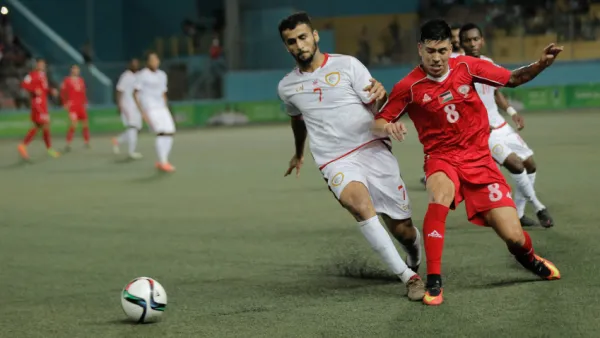 Palestine, in red, vs. Oman at Faisal Husseini Stadium near Jerusalem. Palestine won 2-1. (Photo: Palestinian Football Association)