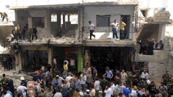 A handout picture released by the Syrian Arab News Agency (SANA) on June 23, 2013, shows civilians and security at the scene of a bombing in Damascus (SANA / AFP)