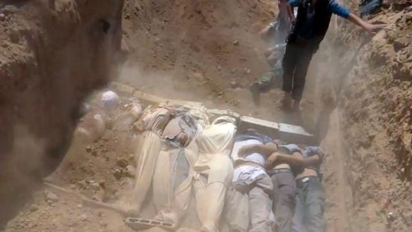 SYRIA, DAMASCUS : An image grab taken from a video uploaded on YouTube by the Local Committee of Arbeen on August 21, 2013 allegedly shows Syrians covering a mass grave containing bodies of victims that Syrian rebels claim were killed in a toxic gas attack by pro-government forces in eastern Ghouta and Zamalka, on the outskirts of Damascus. AFP PHOTO / YOUTUBE / LOCAL COMMITTEE OF ARBEEN