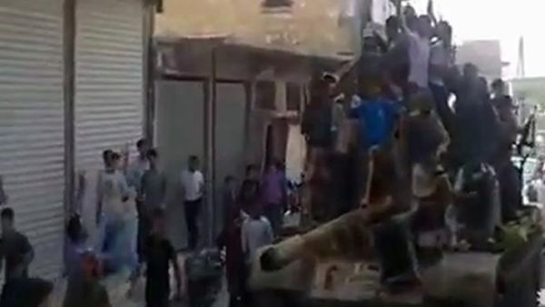 حلبيون يعتلون ظهر دبابة استولىعليها مقاتلون من المعارضة/أ.ف.ب