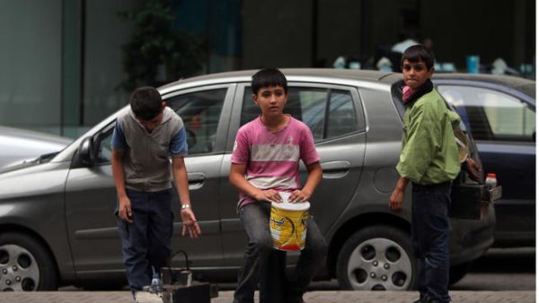 Young Syrian refugees carrying shoe shine kits as they search for customers in a street in Beirutt. Seven million people are in urgent need of humanitarian aid due to the conflict in Syria, a UN top official said. (Image credit: AFP)