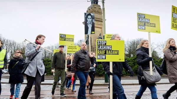 Demonstrators from Amnesty International, a human rights watchdog, protest flogging of jailed Saudi blogger Raif Badawi in front of the Saudi embassy in the Hague.  (AFP/File)