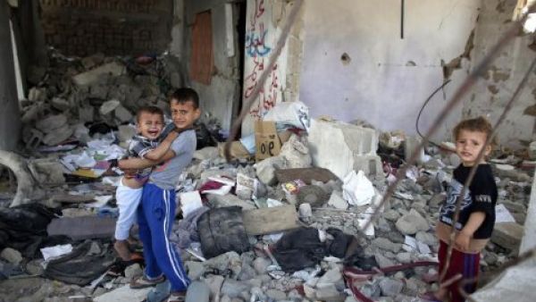 Palestinian children sit in the rubble of their home, destroyed during last summer's conflict between Israel and Hamas militants in the Gaza Strip.  (AFP/Thomas Coex)