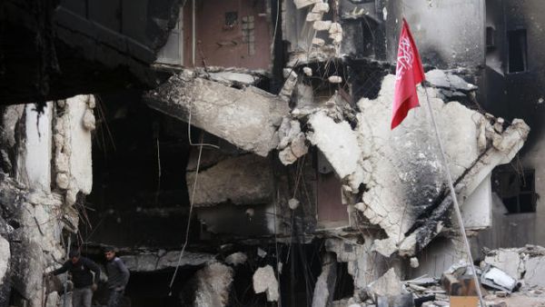 Rebel fighters walk in the rubble of destroyed building in Syria. (Image credit: AFP)