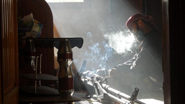 n opposition fighter smokes a cigarette as he takes a break following the injury of his friend. (Image credit: AFP)