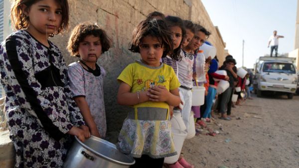 Displaced children in Raqqa, Syria line up for a free iftar meal to break the daily Ramadan fast, July 2013.  (AFP/Mezar Matar)