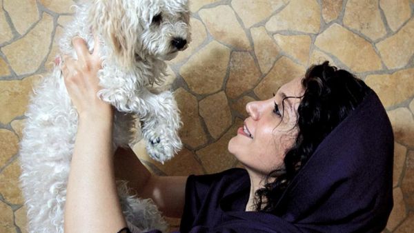 An Iranian woman plays with her pet terrier.  (AFP/Behrouz Mehria)