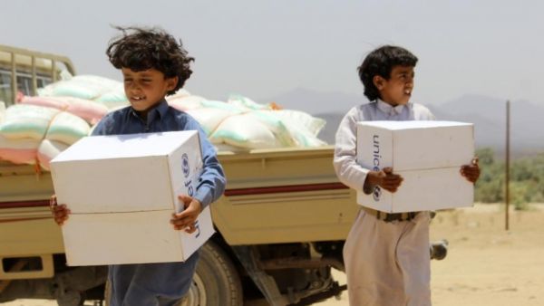 Children carry supplies handed out by UNICEF outside the Yemeni capital Sanaa.  Heavy airstrikes and ground fighting across the country have made it extremely difficult for humanitarian aid to reach Yemen's civilians.  (AFP/File)