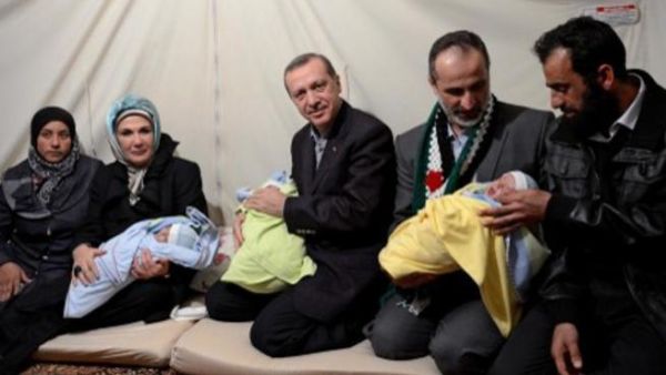 رئيس الوزراء التركي رجب طيب اردوغان وزوجته ورئيس المعارضة معاذ الخطيب في زيارة لمخيم لاجئيين سورييين/أ.ف.ب
