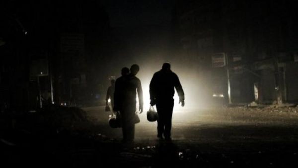 سوريون يسيرون في ظلمة الشوارع بمدينة حلب/أ.ف.ب