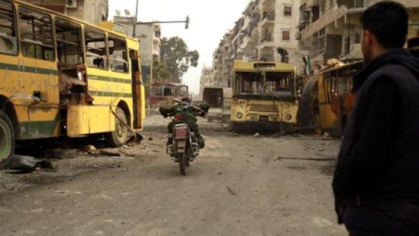 مقاتل من المعارضة يجتاز منطقة يسيطر عليها قناصة النظام على دراجة نارية في حي بستان الباشا بحلب/أ.ف.ب