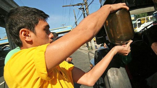 Staff fills up a jeep at a gas station. [gmanetwork]