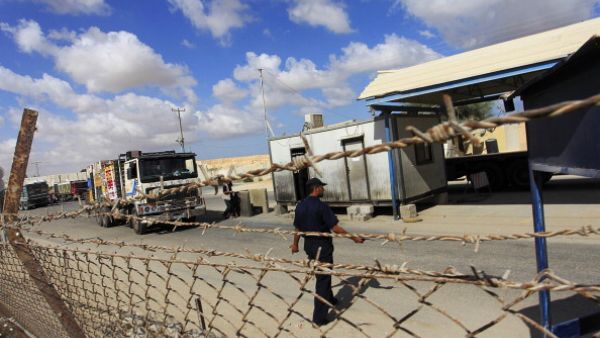 Trucks cross into Rafah town through the Kerem Shalom crossing between Israel and the southern Gaza Strip. [Said Khatib/AFP]