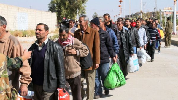 Syrian civilians evacuate the war-battered suburb of Damascus, Moadamiyet al-Sham, with the help of the Social Affairs Ministry, as fighting between pro-government troops and rebel fighters continues in districts of the capital. [AFP/Getty Images]
