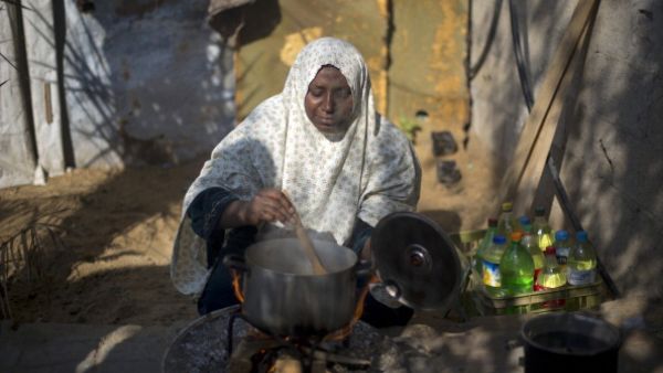 A Palestinian woman cooks her food on fire wood in Biet Hanun northern Gaza Strip, on November 19, 2013, due to the shortage in butane gas across the Hamas run Palestinian territory. [AFP]