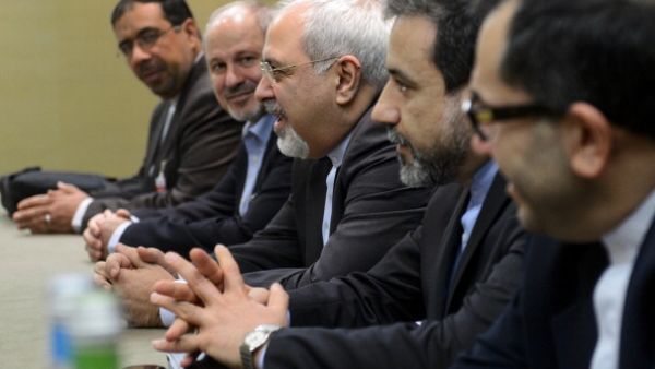 Iranian Foreign Minister Mohammad Javad Zarif attends talks flanked by members of his delegation during talks over Iran's nuclear programme in Geneva on November 22, 2013. [AFP]