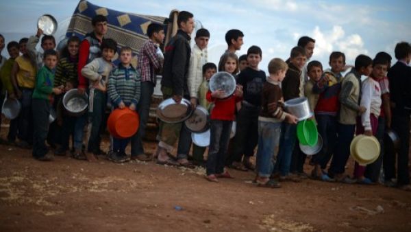 سوريون مهجرون داخل وطنهم يصطفون في طابور لتلقي مساعدات غذائية/أ.ف.ب