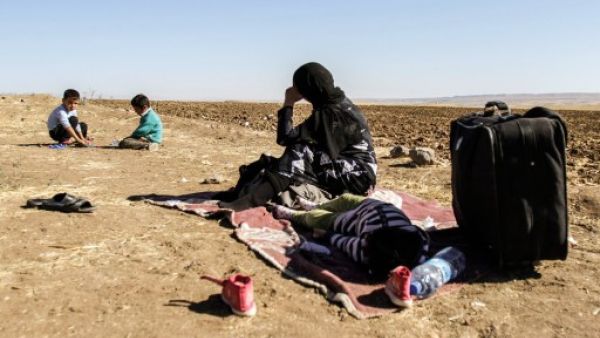 لاجئة سورية مع اطفالها في انتظار نقلها لتركيا/أ.ف.ب