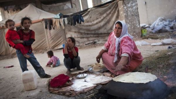 عائلة سورية مهجرة من منزلها في منطقة الشيخ نجار الصناعية في حلب / أ.ف.ب