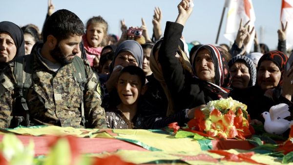 Syrian Kurds mourn next to coffins as they attend the funeral procession of four Kurdish fighters in the northeastern Syrian city of Qamishli on February 18, 2016. (AFP/Delil Souleiman)