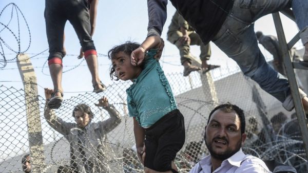 سوريون يعبرون الأسلاك الشائكة باتجاه تركيا