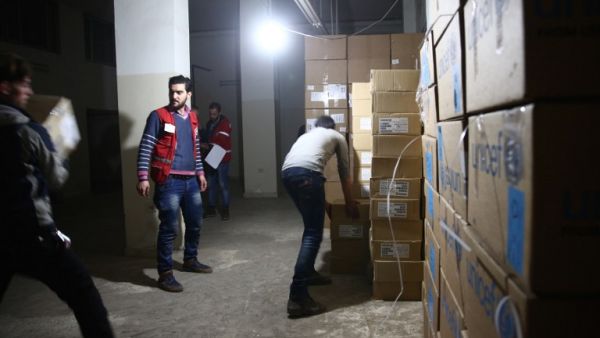 Syrian Red Crescent staff survey the delivery of humanitarian aid in the rebel-held Eastern Ghouta area, on the outskirts of Damascus on Feb. 23, 2016 during an operation to deliver aid to thousands of besieged Syrians. (AFP/Abd Doumany)
