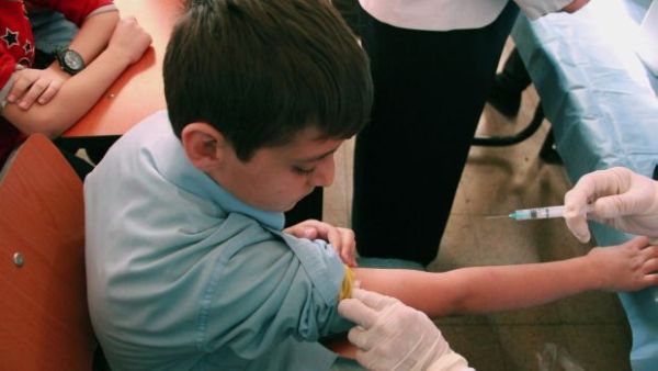 Syrian student receives a vaccination as part of a UNICEF-supported vaccination campaign at a school in Damascus, October 20, 2013. [AP Photo]