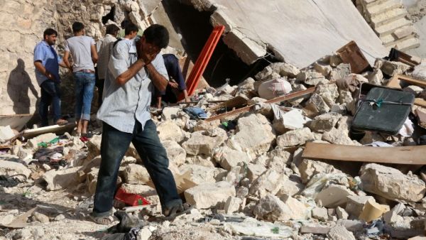 A Syrian man reacts as rescuers look for victims under the rubble of a collapsed building following a reported air strike on the rebel-held neighborhood of Sakhur in Aleppo on July 19, 2016. (AFP/Thaer Mohammed)
