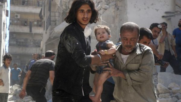 A Syrian civil defence member and a volunteer carry a little girl rescued from under the rubble of destroyed buildings following a reported airstrike on the rebel-held Salihin neighbourhood of the northern city of Aleppo, on September 10, 2016. (AFP/Thaer Mohammed)