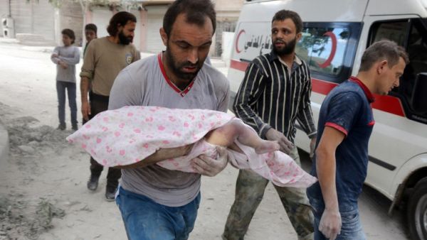 A Syrian man carries the body of an infant retrieved from under the rubble of a building following a reported airstrike on September 23, 2016, on the al-Muasalat area in the northern Syrian city of Aleppo. (AFP/Thaer Mohammed)