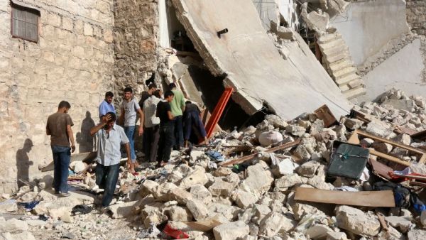 Syrians look for victims under the rubble of a collapsed building following a reported air strike on the rebel-held neighborhood of Sakhur in the northern city of Aleppo on July 19, 2016. (AFP/Thaer Mohammed)