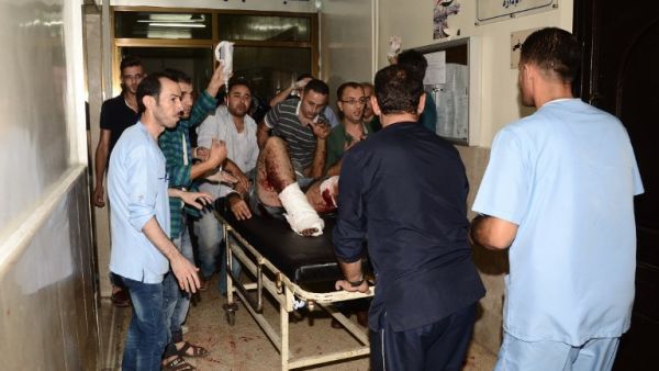 Syrians rush a wounded man into a hospital in the government-controlled side of the northern city of Aleppo following fighting between regime forces and rebels, on October 6, 2016. (AFP/Georges Ourfalian)
