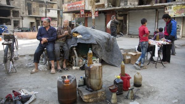 Syrian men sell fuel produced from plastic in the rebel-held side of the northern embattled city of Aleppo on October 27, 2016. (AFP/Karam al-Masri)