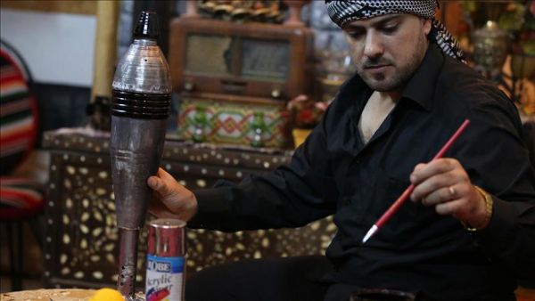 Syrian artist Ekrem Abu al-Fevz is seen with one of his art pieces. (Twitter)